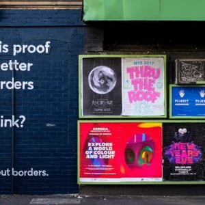 posters mounted on building wall during daytime